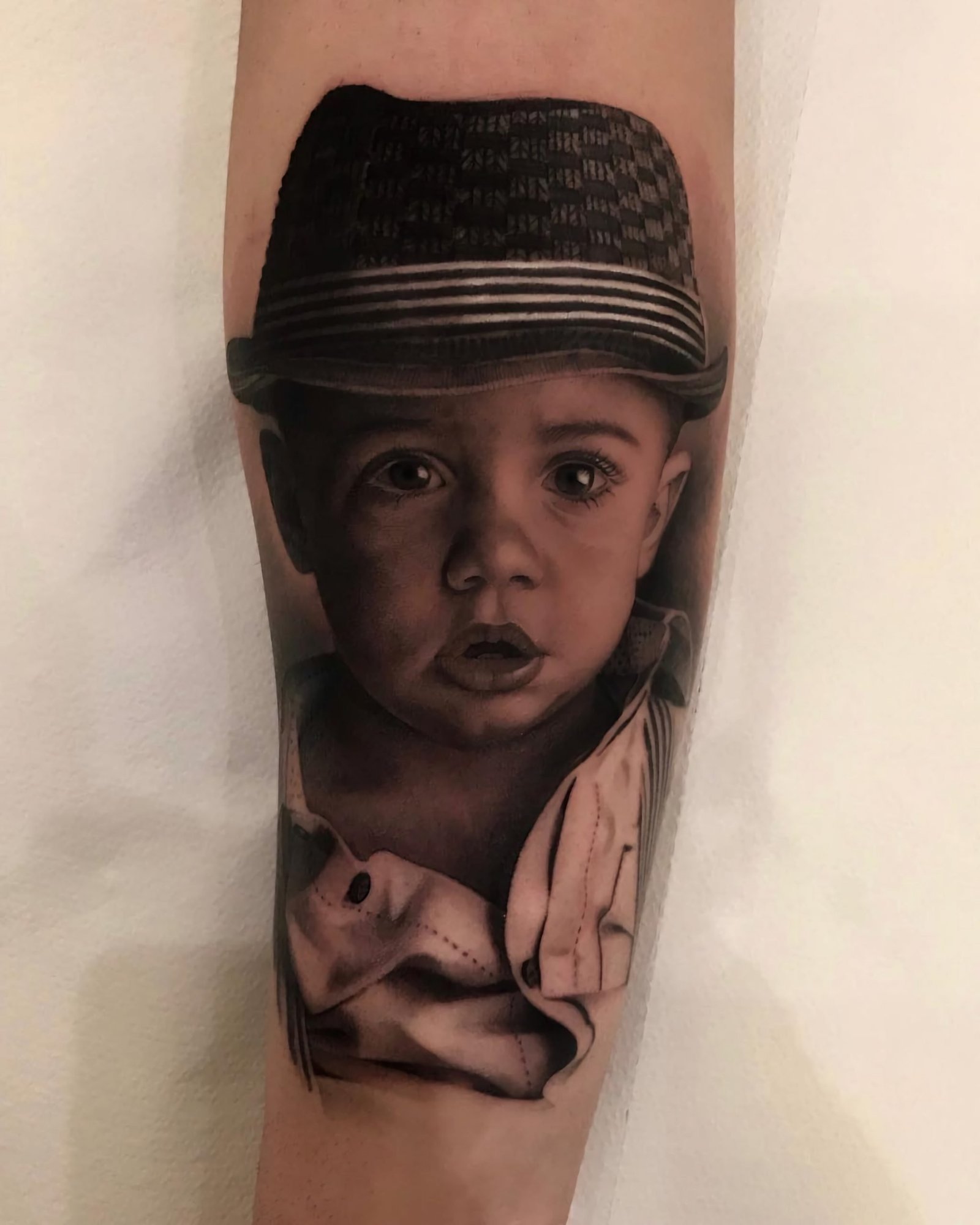 татуировка портрета ребенка на руке