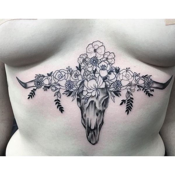 татуировка черепа животного с цветами под грудью